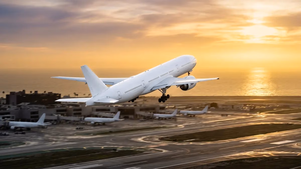 Widebody jet taking off towards the Pacific at sunset
